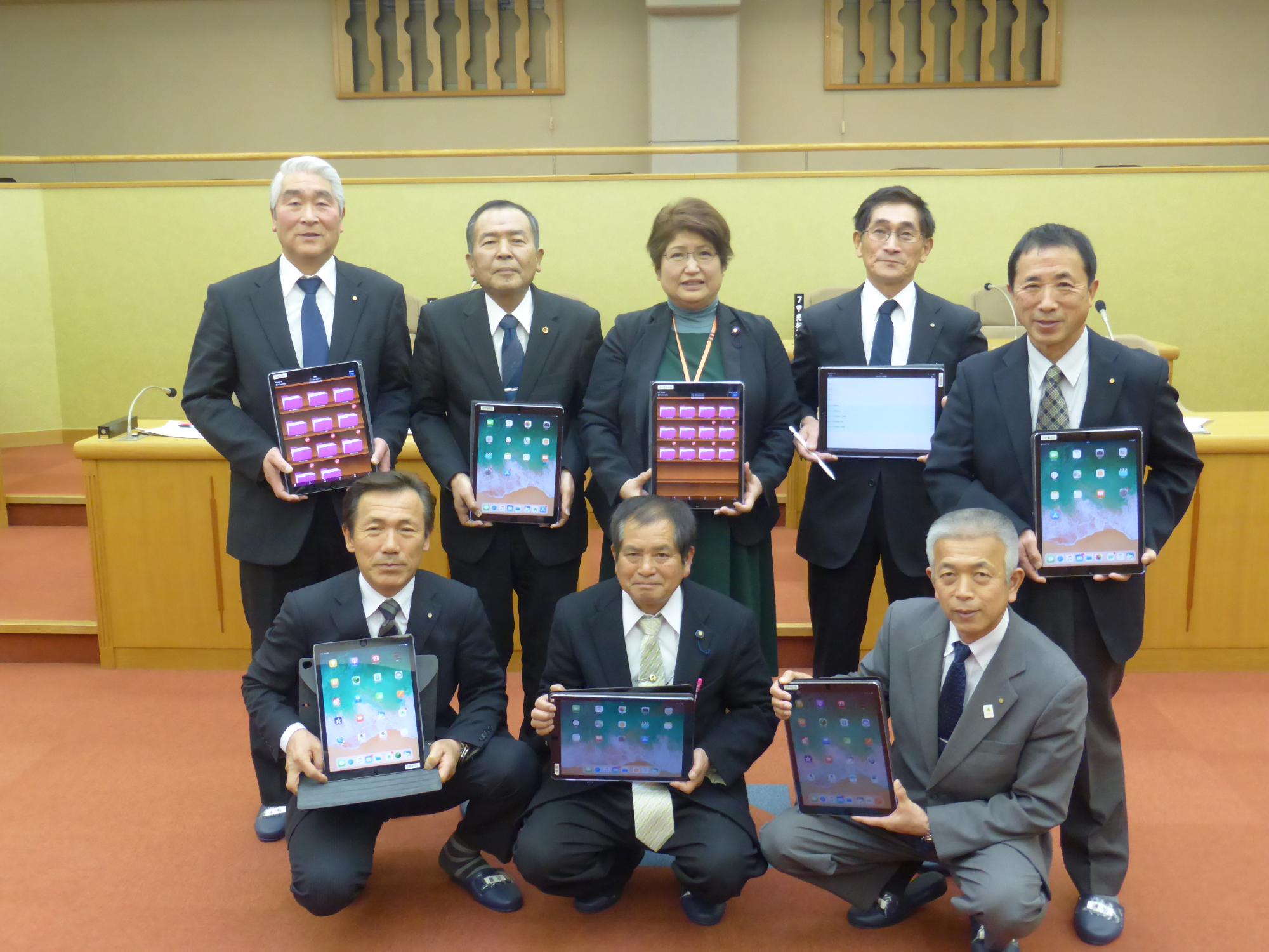 議場でタブレットを掲げる五ヶ瀬町議会議員ら